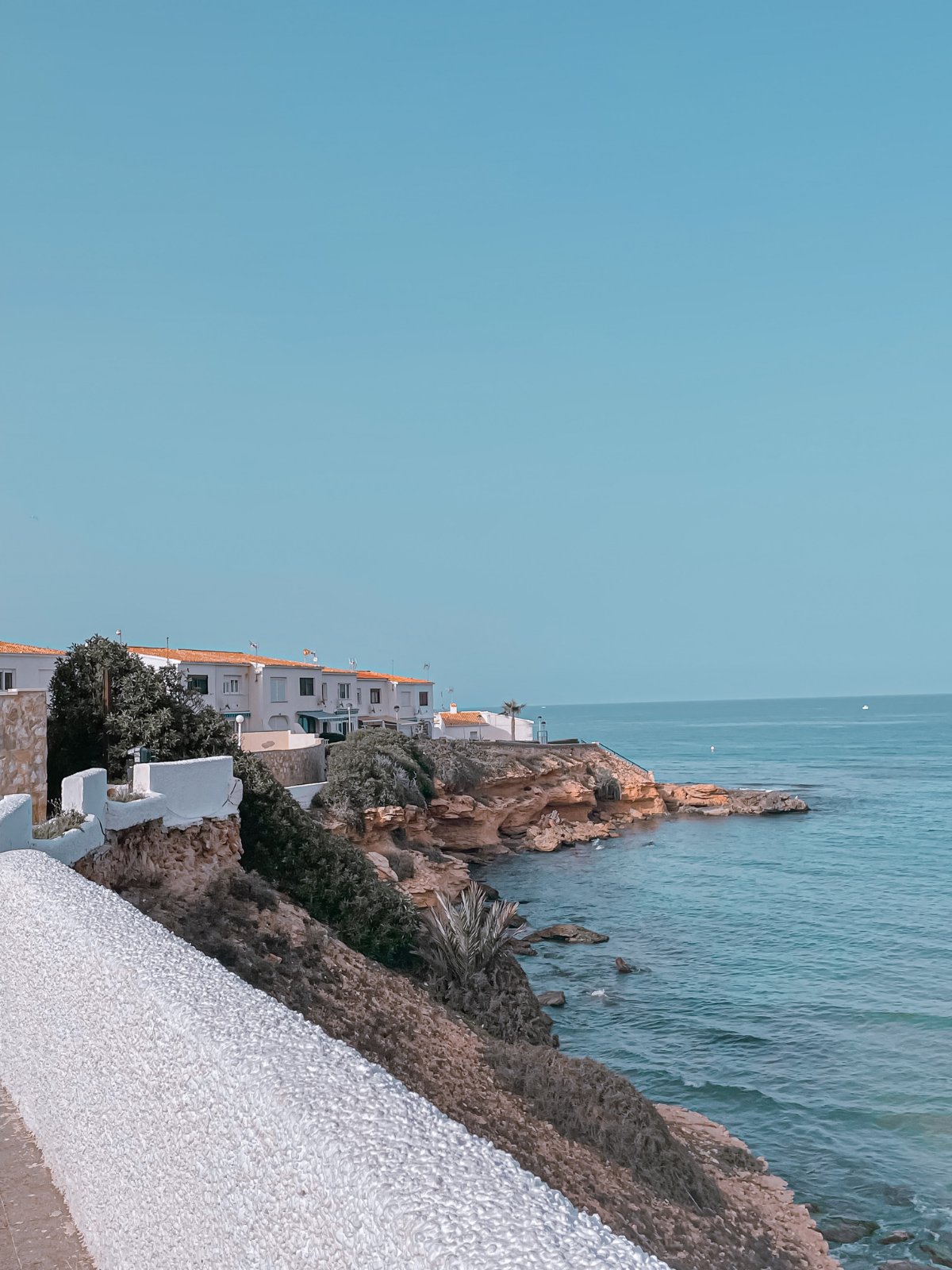 A coastal village in Torrevieja above turquoise Mediterranean water.