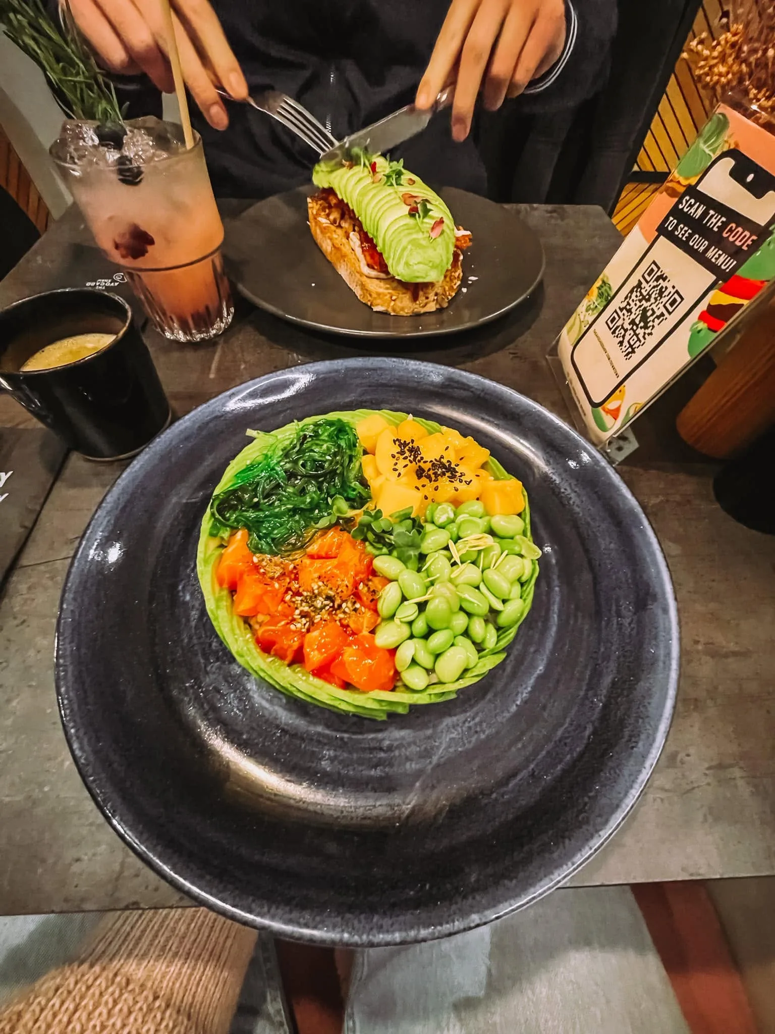 An avocado-topped sandwich and poke bowl